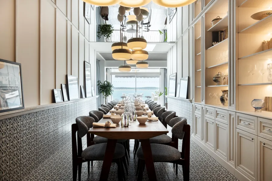La Table du Chef accueille 12 à 16 convives dans un décor lumineux, entre carreaux de ciment, boiseries et horizon marin.
