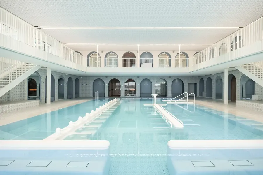 La piscine intérieure occupe le cœur de la Thalasso & Spa, dans un décor lumineux inspiré des architectures balnéaires.