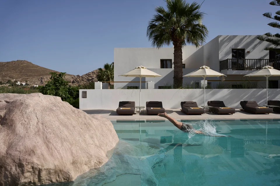 La piscine dialogue avec les formations rocheuses de Paros, dans une composition qui prolonge directement le paysage environnant.
